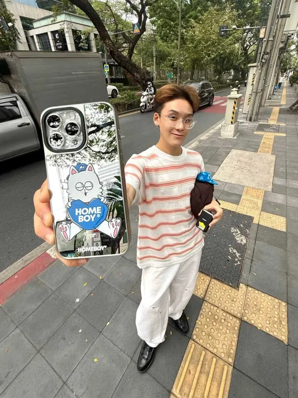 ผู้ชายเสื้อลายทางยืนถือเคสกระจกริมถนน